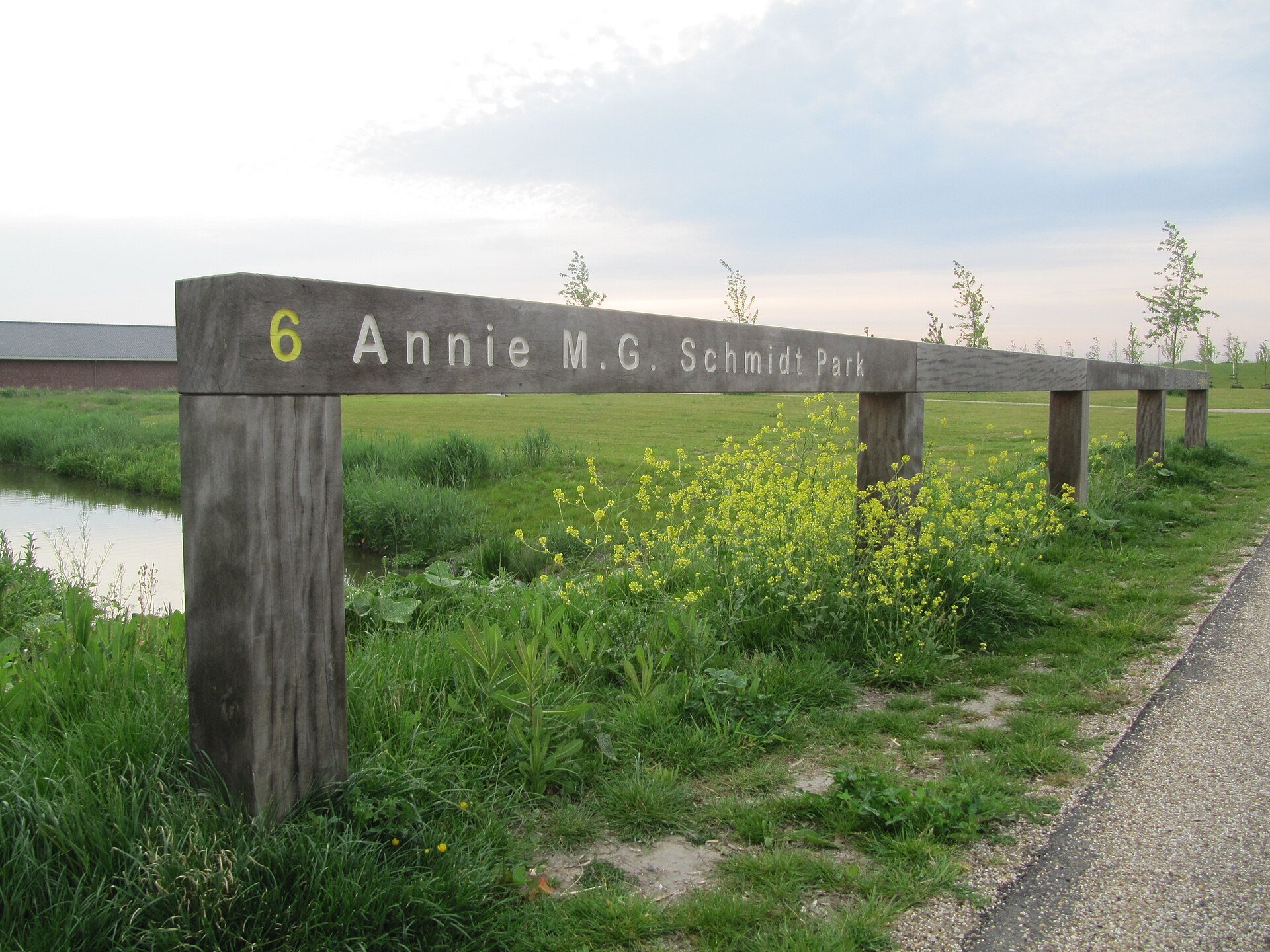 Houten naambord van het Annie M.G. Schmidtpark naast een wandelpad en sloot in Berkel en Rodenrijs
