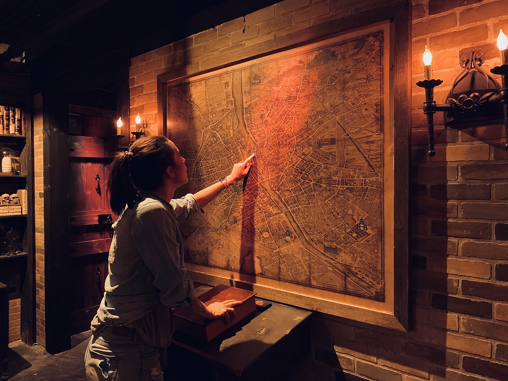 Vrouw lost een puzzel op bij een oude kaart aan de muur in een escape room
