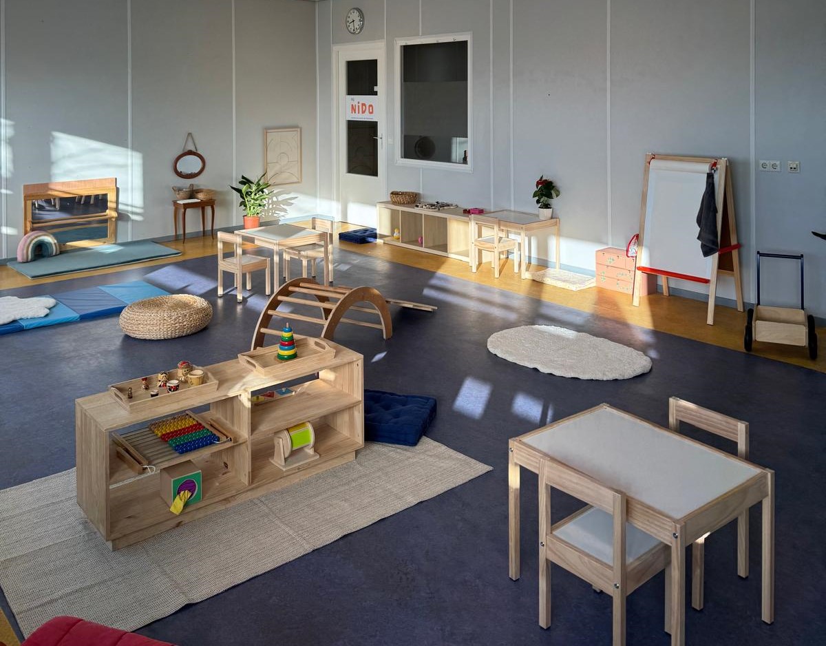 Speellokaal van Bij Nido met Montessori speelgoed, houten meubels en kleden